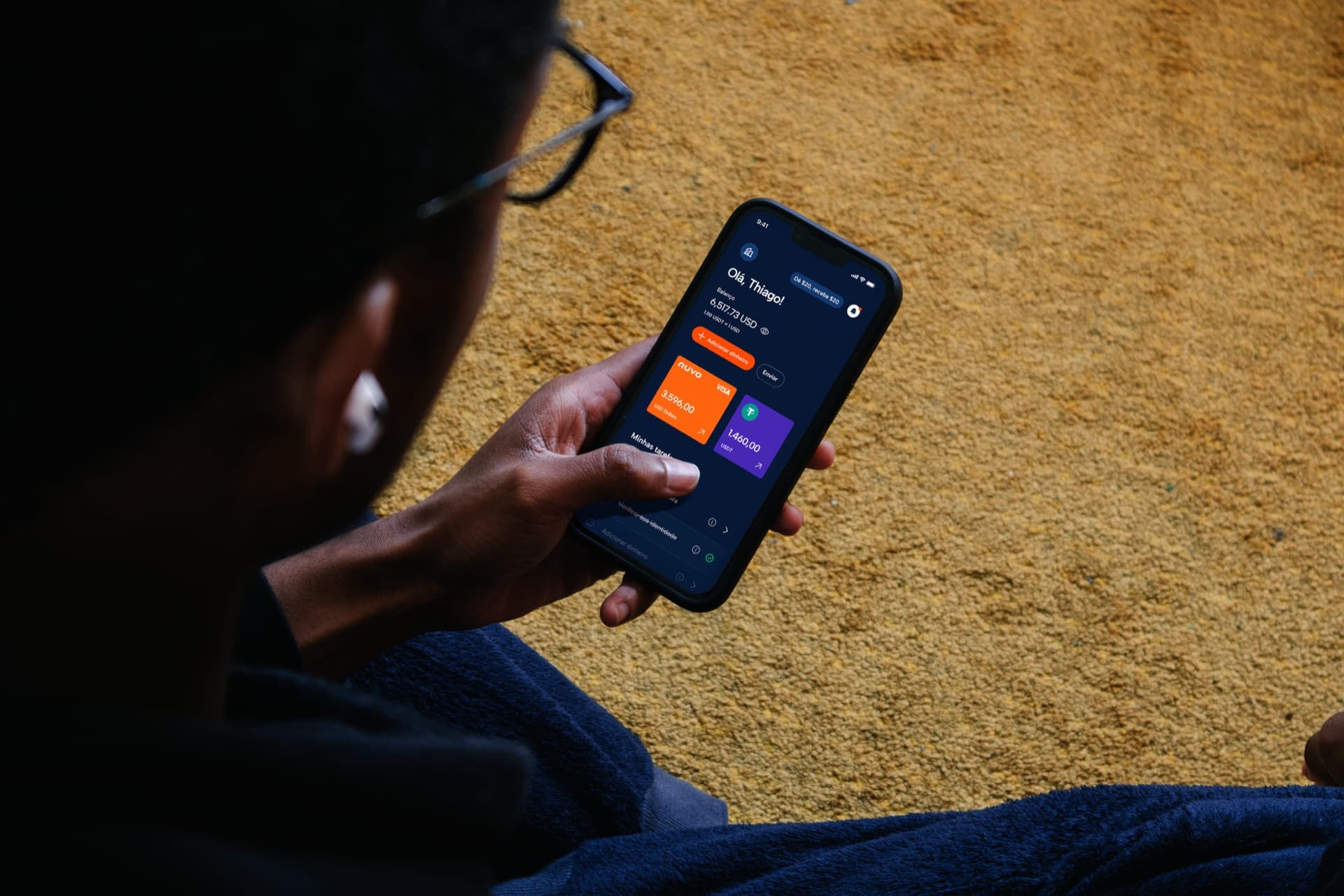 Hand holding a phone showing the Ruvo app