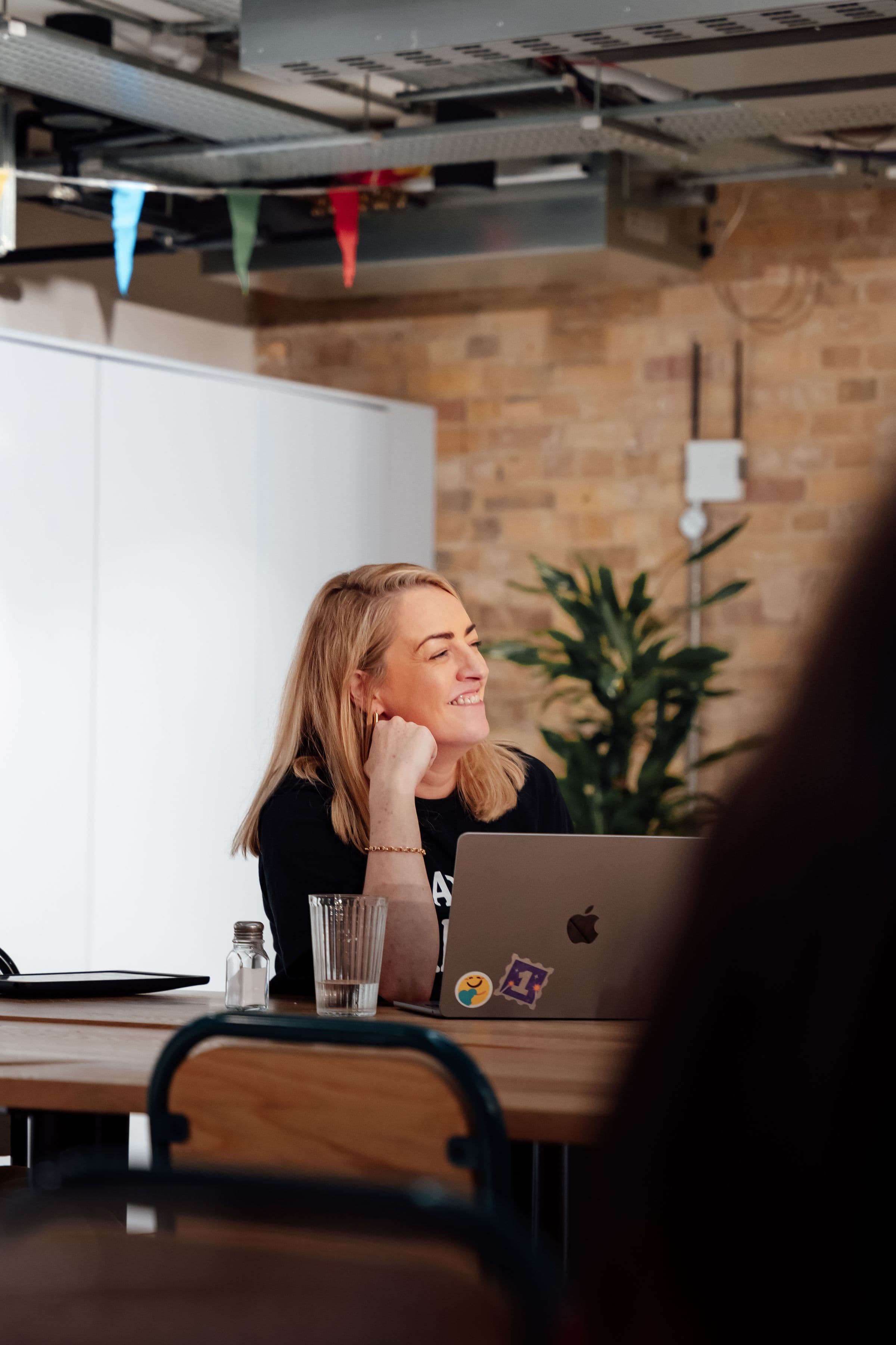 Woman smiling at her laptop in a modern office